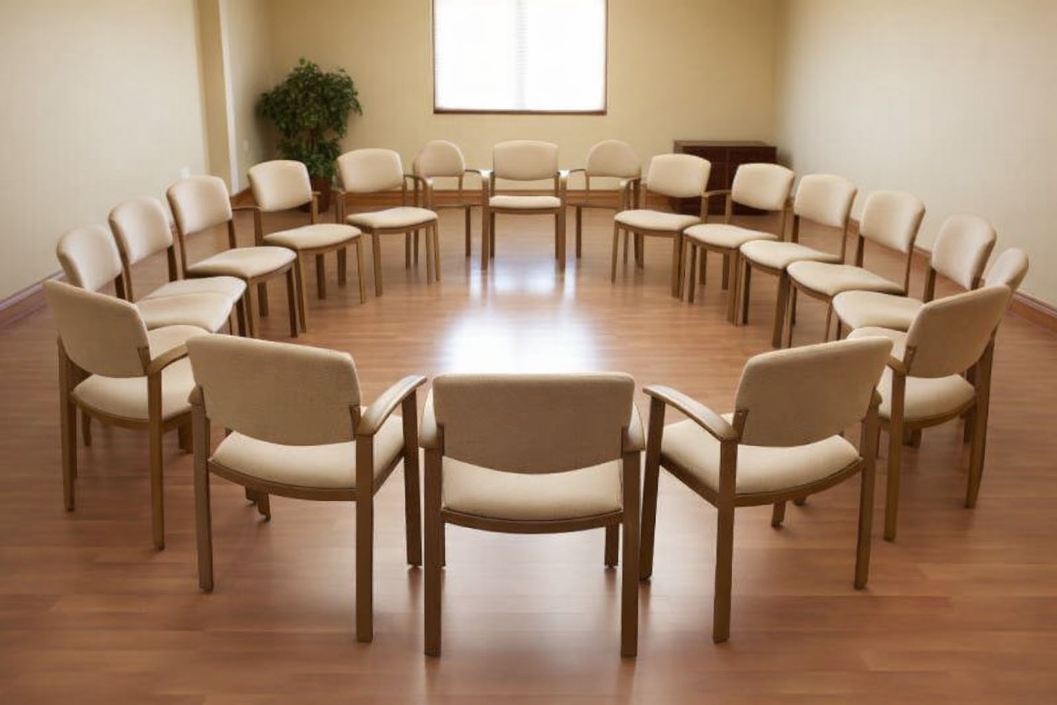 Tomma stolar i en cirkel i ett rum, symboliserar stödgrupper.